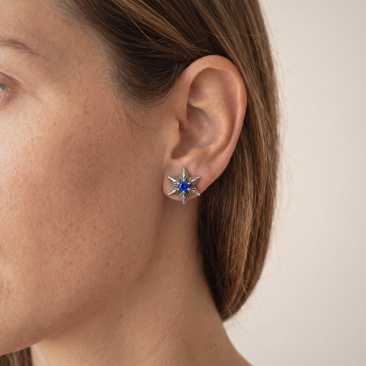 Star of David Stud Earrings in 925 Sterling Silver, Blue Cubic Zirconia - worn on the ear